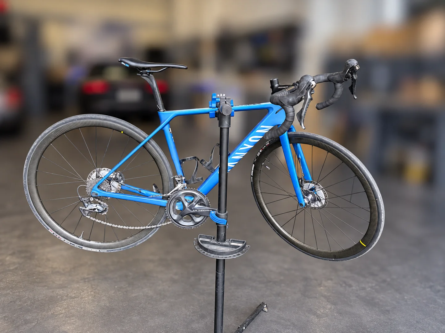 Blaues Canyon Rennrad am Montageständer; Hintergrund anonymisiert