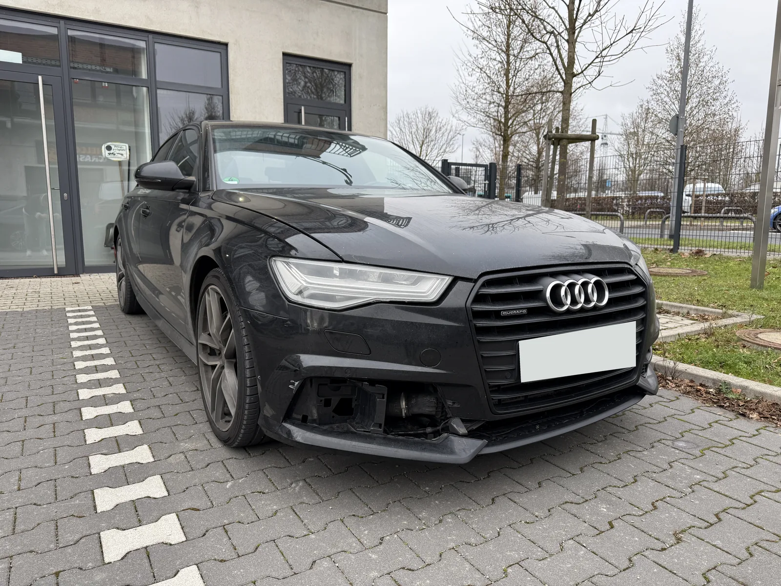 Audi mit beschädigtem vorderem Stoßfänger und veränderter Haubenpassung; Kennzeichen anonymisiert