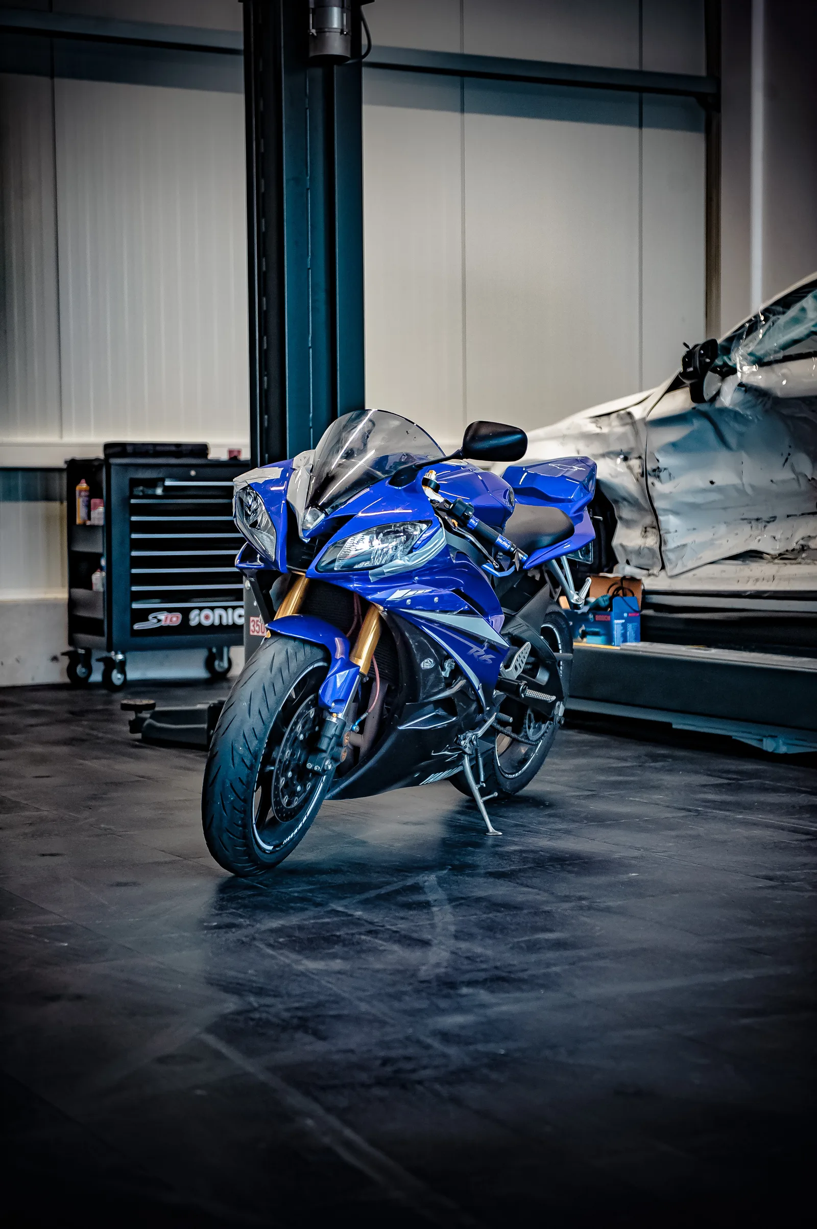 Blaues Motorrad in der Werkstatt nach einem Unfall